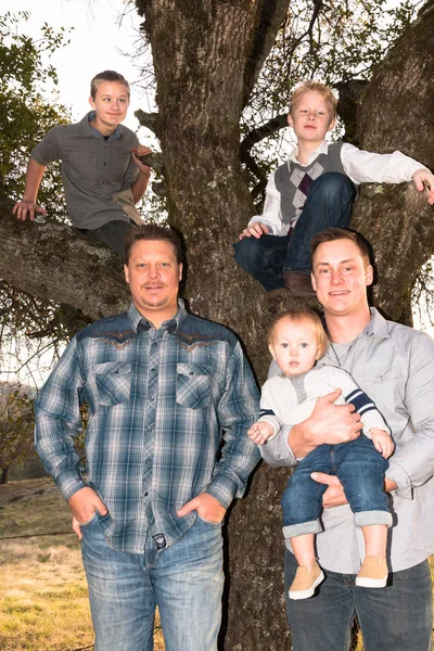 Młodych mężczyzn stojących z chłopców w drzewo — Zdjęcie stockowe