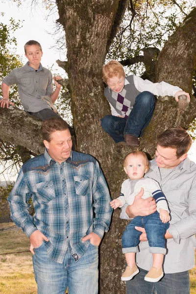 Junge Männer stehen mit Jungen im Baum — Stockfoto