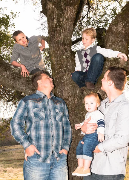 Junge Männer stehen mit Jungen im Baum — Stockfoto