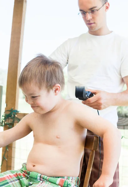 Pequeño niño con síndrome de Downs consiguiendo su corte de pelo — Foto de Stock
