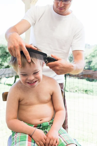 Pequeño niño con síndrome de Downs consiguiendo su corte de pelo — Foto de Stock