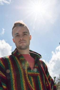 Genç adam güneş ışığı kamerayla bakarak genel gider