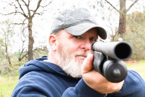 Hombre con barba apuntando a la escopeta —  Fotos de Stock