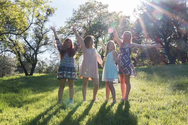 Niñas de pie con los brazos levantados y la luz del sol por encima —  Fotos de Stock