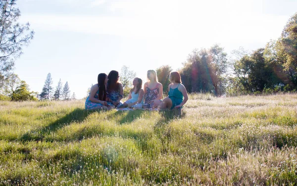 Girls Sitting Together in Grassy Field With Sunlight Overhead — Stock Photo, Image