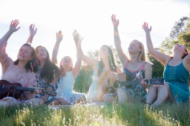 Şarkı ve müzik birlikte çimenli oturan kızlar alan