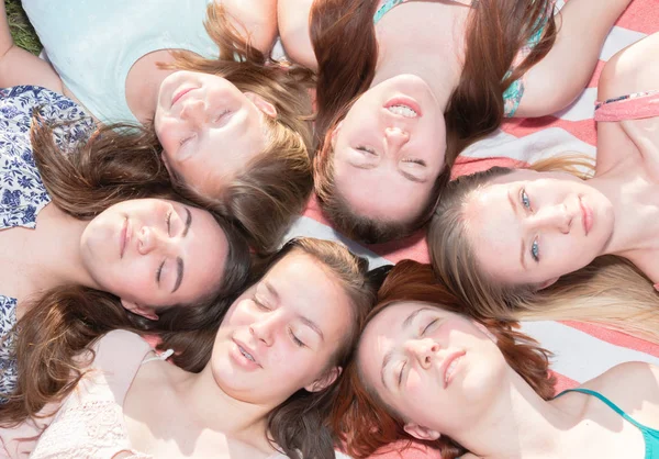 Chicas acostadas en el suelo mirando hacia arriba, algunas con los ojos cerrados — Foto de Stock