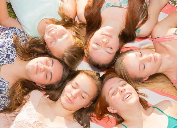 Mädchen, die auf dem Boden liegen und aufblicken, einige mit geschlossenen Augen — Stockfoto