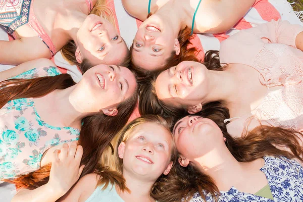 Meninas deitadas no chão olhando para cima, alguns com os olhos fechados — Fotografia de Stock