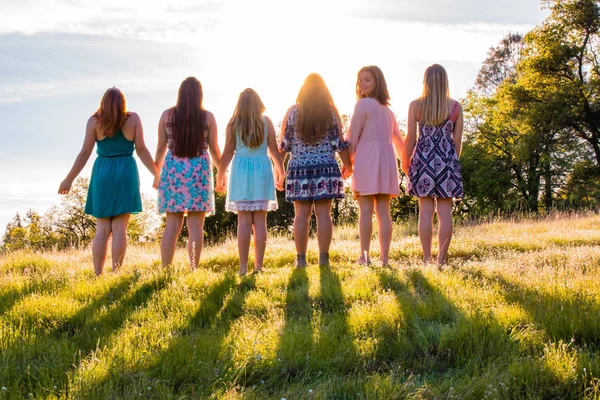 Les filles debout ensemble face au coucher de soleil lumineux — Photo