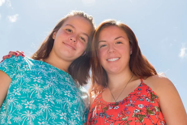 Deux filles avec le ciel bleu et la lumière du soleil en arrière-plan — Photo