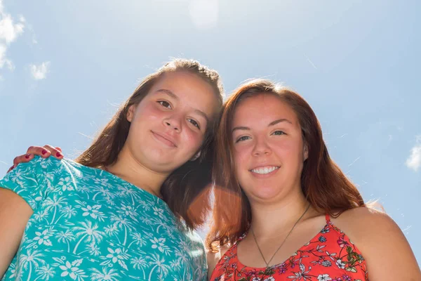 Dos chicas con cielo azul y luz solar en el fondo —  Fotos de Stock