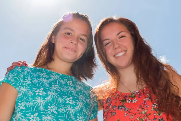 Dvě dívky s modrá obloha a slunce v pozadí — Stock fotografie