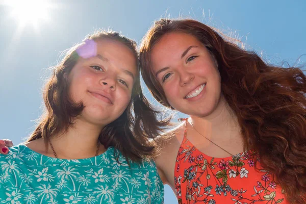 Dos chicas con cielo azul y luz solar en el fondo — Foto de Stock
