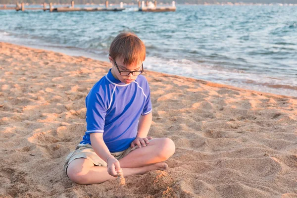 Pojke med Downs syndrom på stranden Royaltyfria Stockbilder