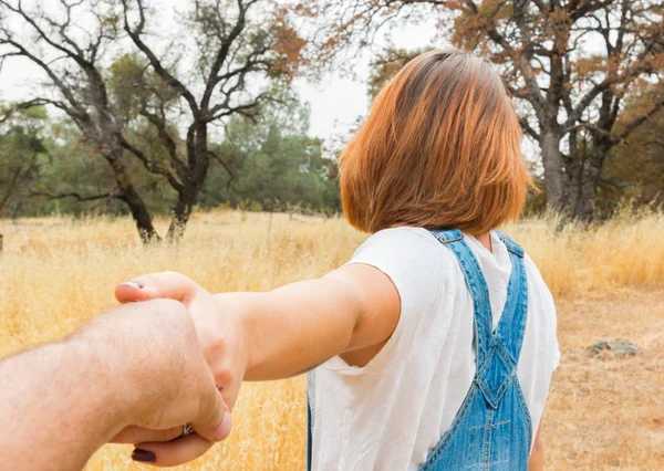 Girl Holding Man Hand in Brown Field — Stock Photo, Image