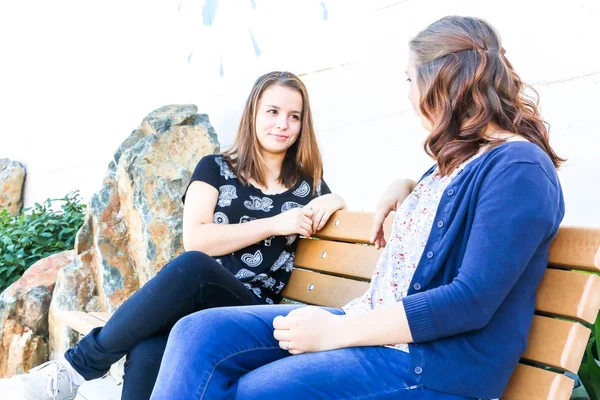 Mädchen sitzen zusammen auf Bank — Stockfoto