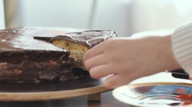 Kız çikolatalı pasta bir parça kesip bir plaka yakın çekim vuruşta yerleştirir