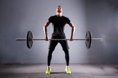 Bir handsom adam kaldırma karakeçi. CrossFit fitness spor salonu ağır bar güçlü egzersiz tarafından