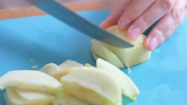 Elma mutfağını kesen genç bir kadın.