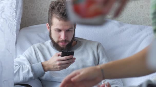 Two male friends talking and drinking tea on sofa at home — Stock Video