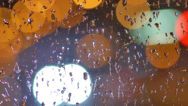 Fond flou. Des cercles bokeh mouvants de circulation nocturne. Feux de circulation nocturnes déconcentrés à travers le verre dans des gouttes de pluie. Coloré, flou, fond bokeh lumières. — Video