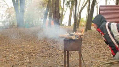 Mutlu grup eğleniyor açık Barbekü Barbekü sonbahar ormanın ortasında, arkadaşıyla