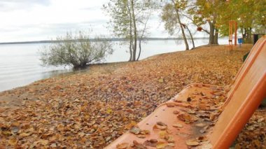 Büyük Göller ve sarı yaprakları ile kum üzerinde çalışırken yavaş dalga tezgah tarafındaki yaprakları sonbahar park düşmek