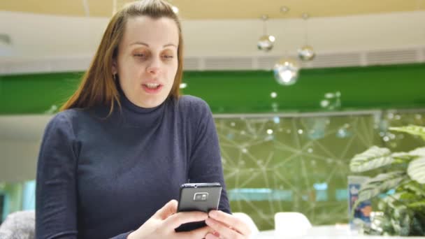 Mutlu genç kız bir mağaza ve manifatura bir mesaj bir smartphone üzerinde duruyor. 4 k Uhd vurdu — Stok video