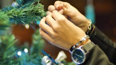 Noel ağacına top asan kadın eller. Kış tatili Noel ve Yeni Yıl Dekorasyonu. Yanıp sönen Garland. Noel ağacı ışıkları parıldıyor.