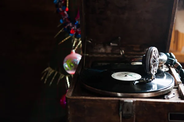 Граммофон играет на пластинке. с винилом на фоне украшения, колпачок, дерево и яркие огни — стоковое фото