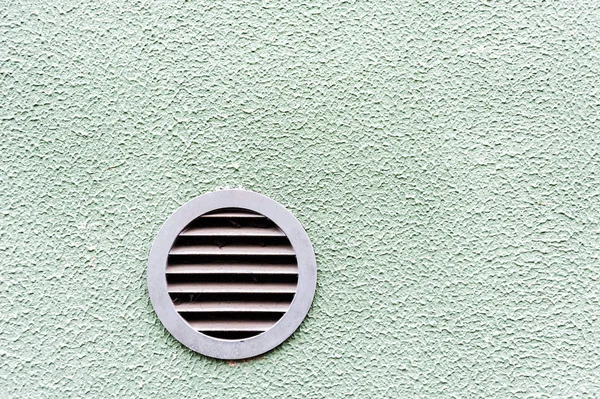 circular plastic air vent in white green wall ventilation grille