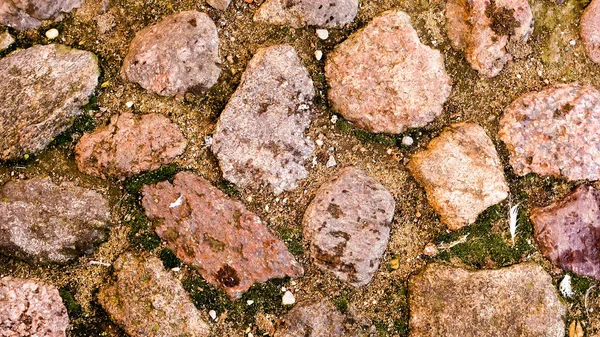 Close-up tiro de pedras ásperas na estrada de paralelepípedos para fundo — Fotografia de Stock