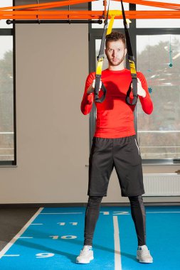 Sportif erkek pull-up ile fitness trx askıları spor salonunda egzersiz
