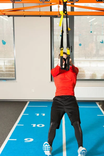 Sportif erkek pull-up ile fitness trx askıları spor salonunda egzersiz — Stok fotoğraf