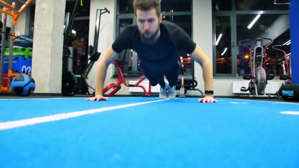 Mladí kavkazské mužské sportovce ve sportovní dělá push up, lidé trénink v tělocvičně, muž, cvičení ve fitness klubu. — Stock video