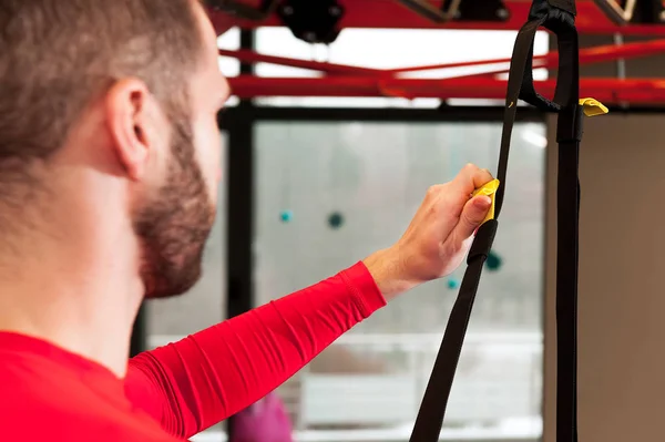 exersising ayar askı kayışları uzunluğu spor salonunda genç sportif sakallı adam hazırlar