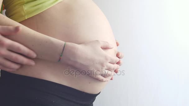 Tender Hands the Future Father. Une femme enceinte debout devant une fenêtre. mains masculines fortes caressé doucement ventre rond — Video