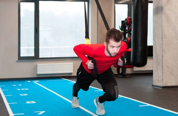 Instrutor de Crossfit no ginásio fazendo Excersise com tiras. Homem de fitness exercita-se nos anéis. Homem de fitness no ginásio. Estilo fitness. Treino em anéis. Desporto e fitness. Treino Crossfit — Fotografia de Stock