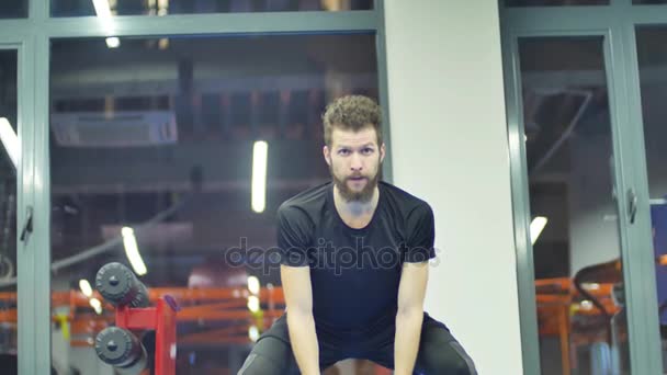 Střední záběr mladý muž cvičení paže a ramena s lanem v tělocvičně — Stock video