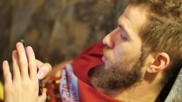 Une jeune brune blanche à barbe bouclée utilise le téléphone mains rapprochées à l'aide d'un écran tactile de téléphone portable — Video