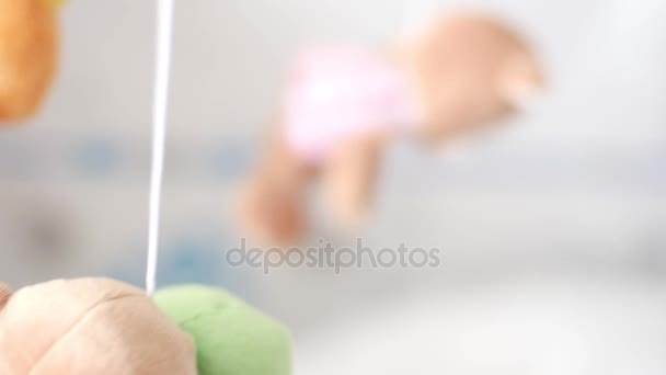 Dolly shot of the carousel with toys on a newborn baby face shallow depth of field — Stock Video