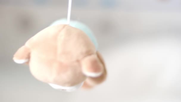 Dolly shot della giostra con giocattoli su un neonato faccia superficiale profondità di campo — Video Stock