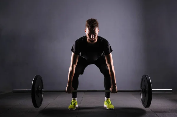 Bir handsom adam kaldırma karakeçi. CrossFit fitness spor salonu ağır bar güçlü egzersiz tarafından — Stok fotoğraf