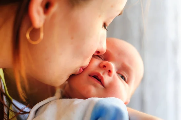 Jonge moeder haar kleine pasgeboren baby kussen — Stockfoto