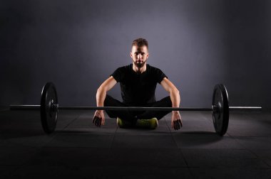 Yakışıklı halterci eğitim için hazırlanıyor. Alan, seçici odak sığ derinliği. Düşük anahtar