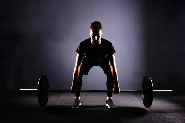 Bir handsom adam kaldırma karakeçi. CrossFit fitness spor salonu ağır bar güçlü egzersiz tarafından