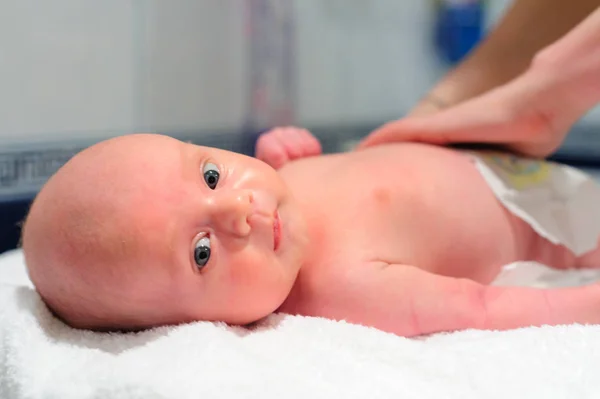 Annem bebeğe bebek bezi takıyor.