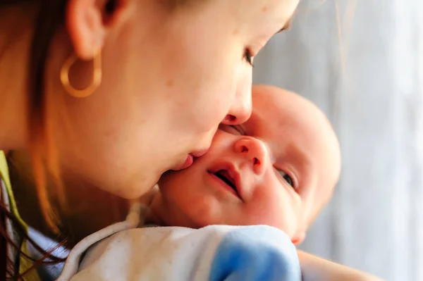 Молода мати цілує свою маленьку новонароджену дитину — стокове фото