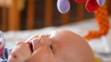 Tatlı bebek çocuk gülümseme renkli bir oyuncakla oynamak
